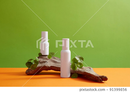 Front view of centella asiatica ( gotu kola ) decorated with cosmetic jar and branch tree in green background Front view of centella asiatica ( gotu kola ) decorated with cosmetic jar and branch tree in green background 91399856