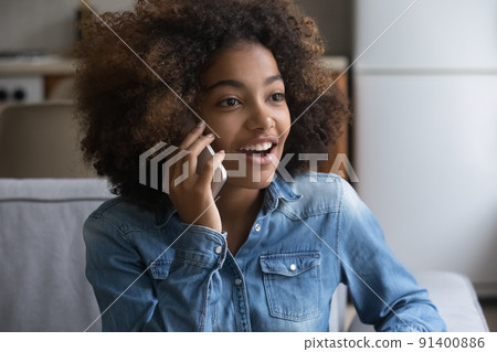 Closeup surprised African girl listens good news by phone call 91400886