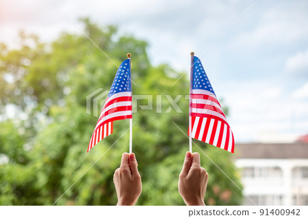 hand holding United States of America flag on green background. USA holiday of Veterans, Memorial, Independence ( Fourth of July) and Labor Day concept hand holding United States of America flag on green background. USA holiday of Veterans, Memorial, Independence ( Fourth of July) and Labor Day concept 91400942