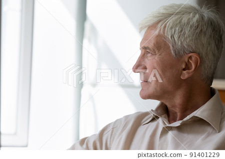 Side profile view pensive older man sit staring out window Side profile view pensive older man sit staring out window 91401229