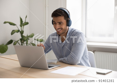 Businessman in headphones working on-line use laptop in office Businessman in headphones working on-line use laptop in office 91401281