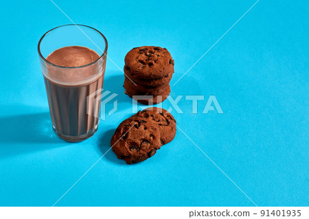 Chocolate milk with cookies on blue background with space for text or design 91401935