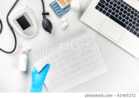 Top view of doctor's hand with result of the survey, digital blood pressure monitor on white table 91405272