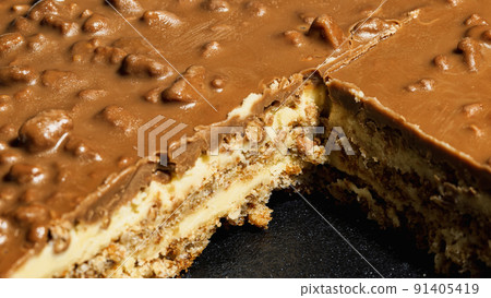 Slice of Swedish almond and chocolate cake with filling and nuts 91405419