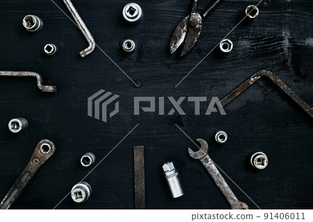 Old, rusty tools lying on a wooden table. Hammer, chisel, metal scissors, wrench, chisel. 91406011