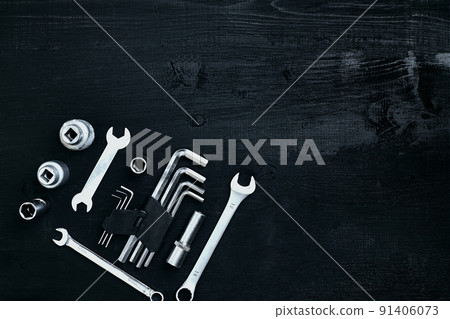 Flat lay of set of tools for car repairing such as wrenches on black wooden background. Top view. 91406073