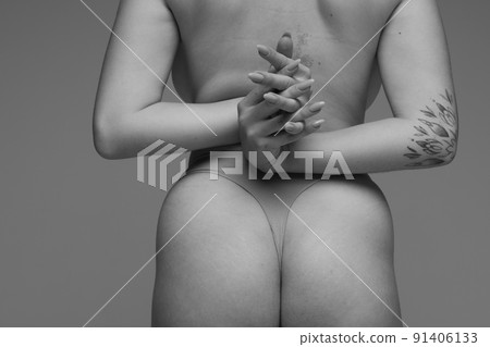 Cropped rear view image of female back and buttocks. Black and white photography. Medical care Cropped rear view image of female back and buttocks. Black and white photography. Medical care 91406133
