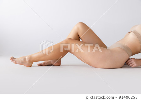 Cropped image of beautiful smooth female legs isolated over grey studio background. Epilation, depilation care Cropped image of beautiful smooth female legs isolated over grey studio background. Epilation, depilation care 91406255