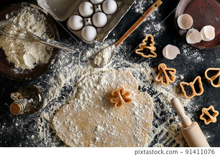 Dough for ginger biscuits rolled up on a table and cut using molds Dough for ginger biscuits rolled up on a table and cut using molds 91411076