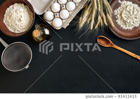 Preparation cooking baking kitchen table brown dishes ware fresh grocery different ingredients: eggs, flour, oil, stuff top view Preparation cooking baking kitchen table brown dishes ware fresh grocery different ingredients: eggs, flour, oil, stuff top view 91411413