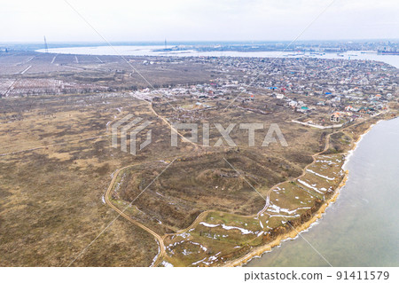 Historical fortification in the field. The remains of the defense system of the city of Nikolaev. Flight over the winter river 91411579