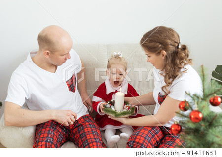 Child with cochlear implant hearing aid having fun with parents in christmas living room - diversity , deafness treatment and medical innovative technologies 91411631