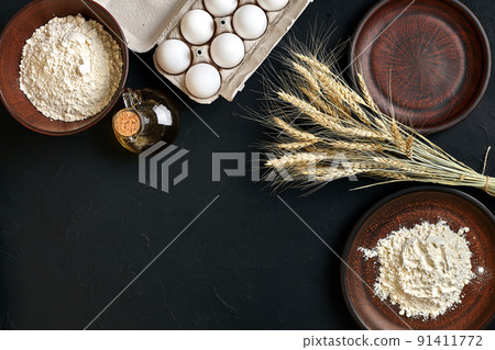 Preparation cooking baking kitchen table brown dishes ware fresh grocery different ingredients: eggs, flour, oil, stuff top view Preparation cooking baking kitchen table brown dishes ware fresh grocery different ingredients: eggs, flour, oil, stuff top view 91411772