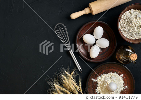 Preparation cooking baking kitchen table brown dishes ware fresh grocery different ingredients: eggs, flour, oil, stuff top view Preparation cooking baking kitchen table brown dishes ware fresh grocery different ingredients: eggs, flour, oil, stuff top view 91411779