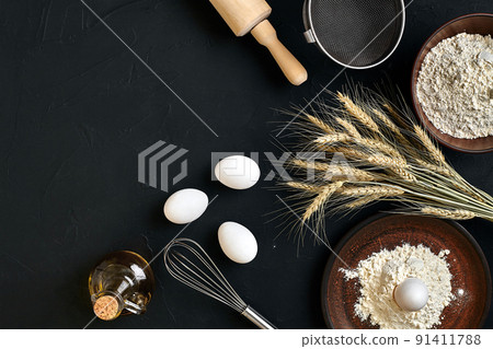 Preparation cooking baking kitchen table brown dishes ware fresh grocery different ingredients: eggs, flour, oil, stuff top view Preparation cooking baking kitchen table brown dishes ware fresh grocery different ingredients: eggs, flour, oil, stuff top view 91411788