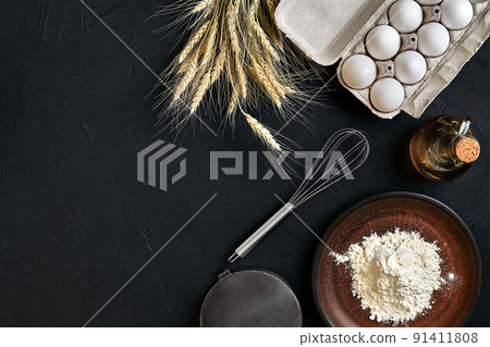 Preparation cooking baking kitchen table brown dishes ware fresh grocery different ingredients: eggs, flour, oil, stuff top view Preparation cooking baking kitchen table brown dishes ware fresh grocery different ingredients: eggs, flour, oil, stuff top view 91411808