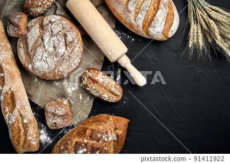 Bakery - gold rustic crusty loaves of bread and buns on black chalkboard background. Bakery - gold rustic crusty loaves of bread and buns on black chalkboard background. 91411922