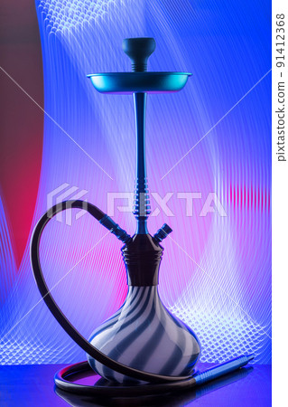 Blue hookah with black rubber tube and blue and white flask on interesting colorful background. 91412368