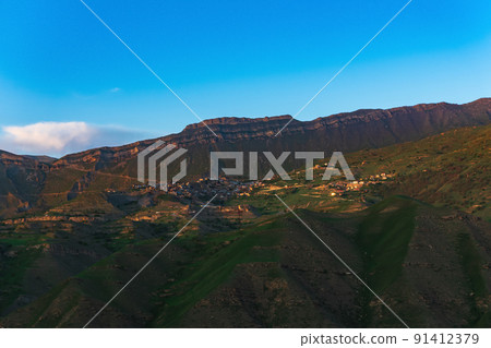 mountain landscape with a village on a slope under a huge rocky ridge, Chokh in Dagestan 91412379