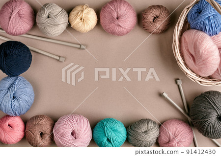 Set of colorful wool yarn on beige background. Top view. Frame of tangles of knitting threads Set of colorful wool yarn on beige background. Top view. Frame of tangles of knitting threads 91412430