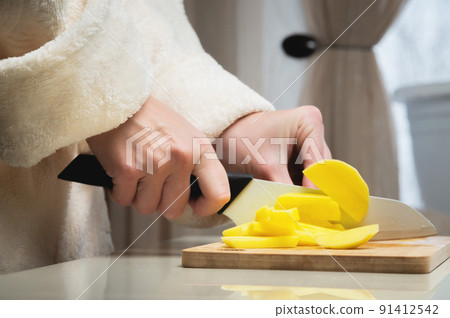 Close-up of female hands cutting fresh peeled potatoes tomatoes on cutting board at home kitchen Close-up of female hands cutting fresh peeled potatoes tomatoes on cutting board at home kitchen 91412542