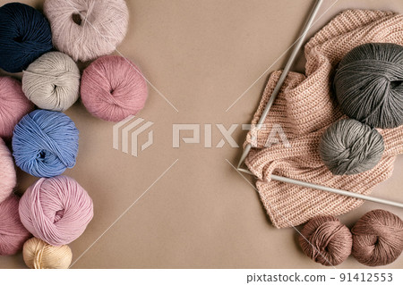 Set of colorful wool yarn and knitting on knitting needles on beige background. Top view Set of colorful wool yarn and knitting on knitting needles on beige background. Top view 91412553
