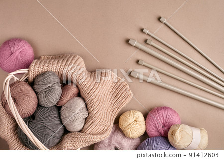 Different colored yarn in basket with knitting needles. Top view Different colored yarn in basket with knitting needles. Top view 91412603