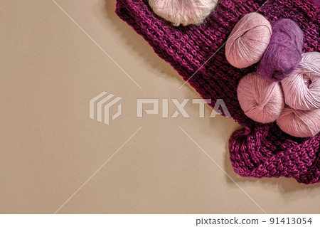 Balls of yarn and knitting needles. Colored yarn for knitting in a wicker bowl on a beige background. Balls of yarn and knitting needles. Colored yarn for knitting in a wicker bowl on a beige background. 91413054