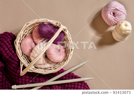 Balls of woolen threads and knitting needles. Scandinavian style. Threads for knitting in a basket. Balls of woolen threads and knitting needles. Scandinavian style. Threads for knitting in a basket. 91413073
