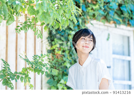 Young woman refreshing on the fresh green terrace Young woman refreshing on the fresh green terrace 91413216