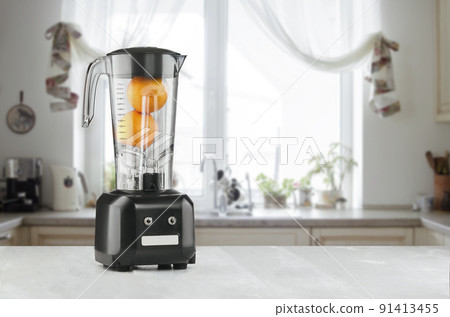 Orange juice blender machine in the kitchen interior 91413455