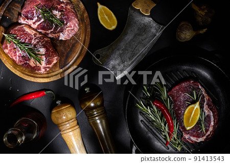 Fresh raw meat. Beef Tenderloin and marbled beef steaks on grill pan and frying board with seasoning, black background top view. Fresh raw meat. Beef Tenderloin and marbled beef steaks on grill pan and frying board with seasoning, black background top view. 91413543