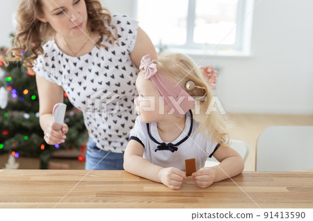 Mother fixing her daughter's cochlear implant hearing aid - deafness and diversity concept. Innovative technologies in treatment of deafness Mother fixing her daughter's cochlear implant hearing aid - deafness and diversity concept. Innovative technologies in treatment of deafness 91413590