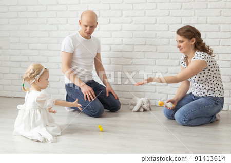 Baby child with hearing aids and cochlear implants plays with parents on floor. Deaf and rehabilitation concept 91413614