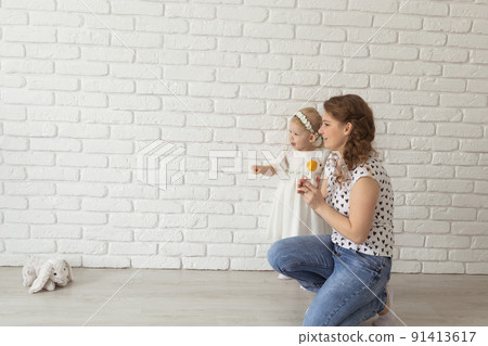 Banner baby child with hearing aids and cochlear implants plays with parents on floor, copy pace and place for advertising. Deaf and rehabilitation and diversity concept 91413617