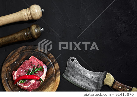 Raw beef steak dry aging on wooden cutting board. Copy space 91413870