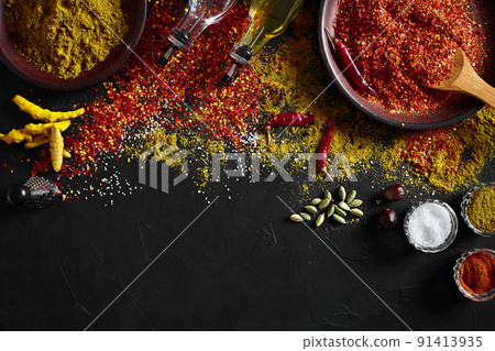 Set of indian spices on black background - green cardamom, turmeric powder, coriander seeds, cumin, and chili, top view 91413935