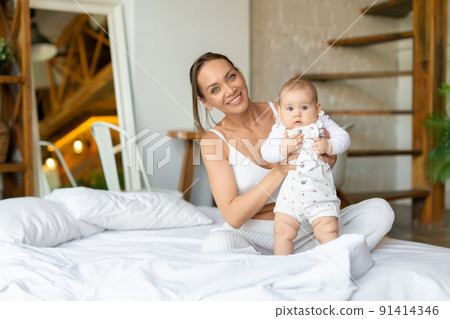 Mother and her baby girl looking at camera. 91414346