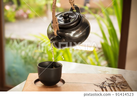 hand pour Chinese or Japanese traditional tea from clay pot 91414523