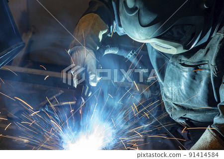 Workers wearing industrial uniforms and Welded Iron Mask at Steel welding plants, industrial safety first concept. Workers wearing industrial uniforms and Welded Iron Mask at Steel welding plants, industrial safety first concept. 91414584
