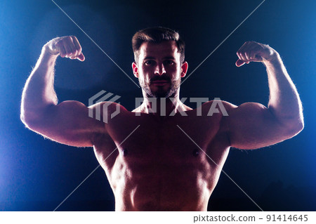 Muscular torso of sexy young fitness male bodybuilder model power athletic man with perfect muscles six pack abs and bare nude chest posing on dark background 91414645