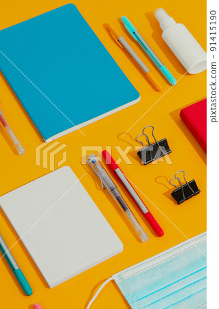 Colorful notepads, pens and hand sanitizer on orange table 91415190