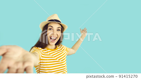 Joyful crazy woman who reaches out to camera to have fun and show copy space behind her. Joyful crazy woman who reaches out to camera to have fun and show copy space behind her. 91415270