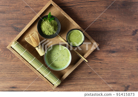 Organic green matcha tea and tea accessories on tray on wooden table top view. Japanese tea ceremony concept. 91415873