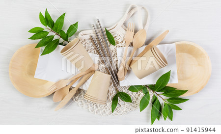 Eco friendly disposable dishes made of bamboo wood and paper on white wooden background. 91415944