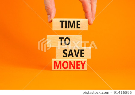Time to save money symbol. Concept words Time to save money on wooden blocks on a beautiful orange table orange background. Businessman hand. Business, finacial and time to save money concept. 91416896