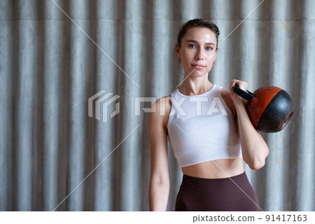 Portrait of a woman with kettlebell in her hand Portrait of a woman with kettlebell in her hand 91417163