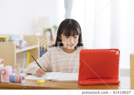 Girl elementary school student studying on a tablet PC 91419607
