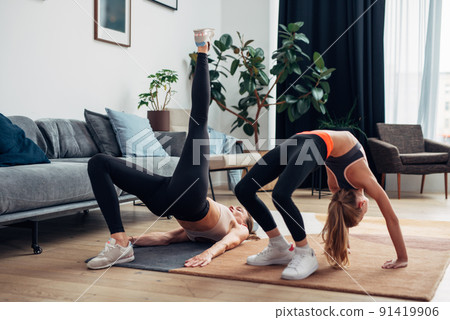 Home workout mother and daughter do bridge and gluteal bridge 91419906
