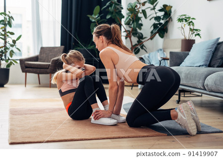 Mother and daughter abdominal muscle training. Home training. 91419907
